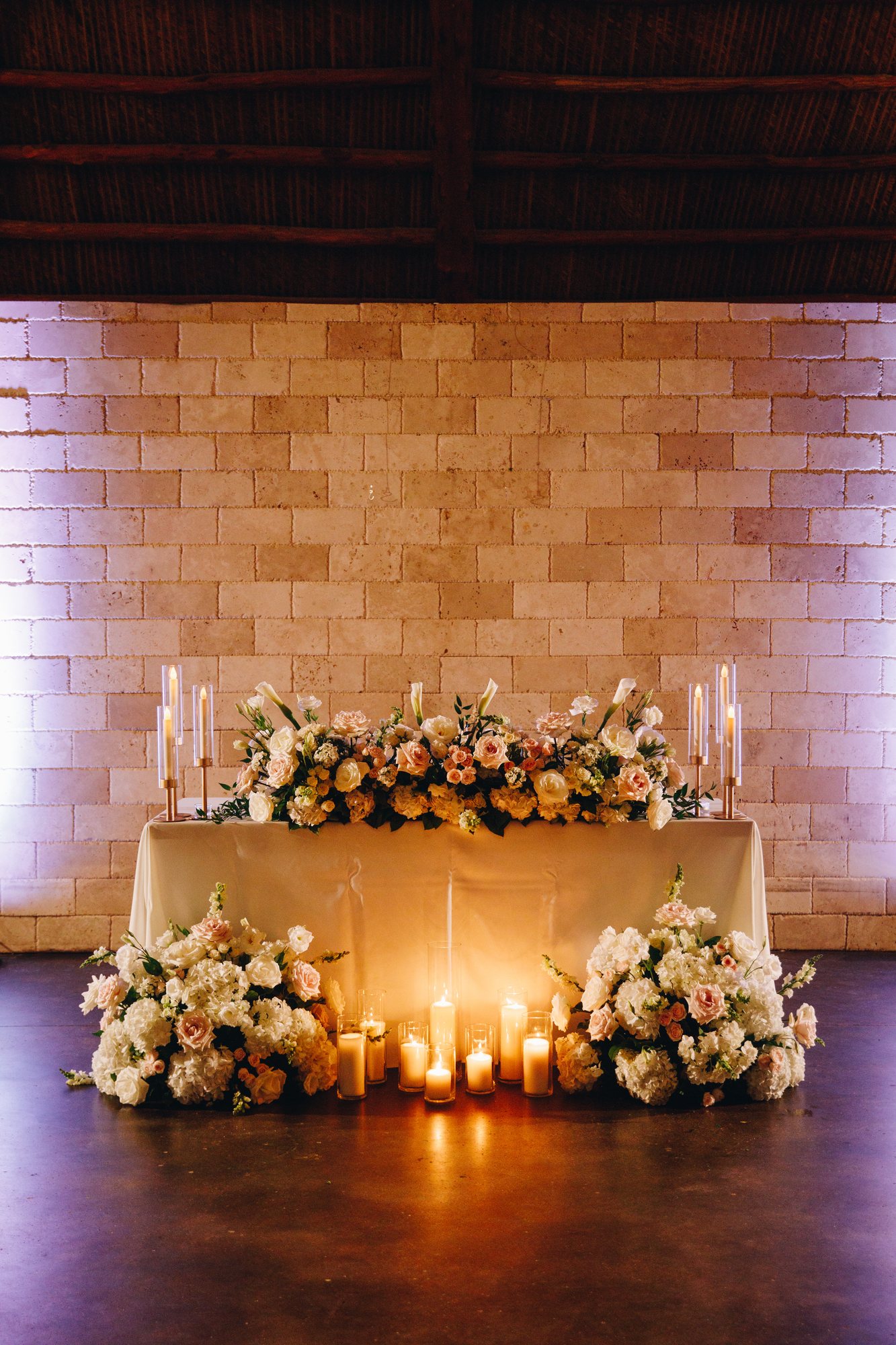 Candlelit sweetheart table decorated with warm garden florals