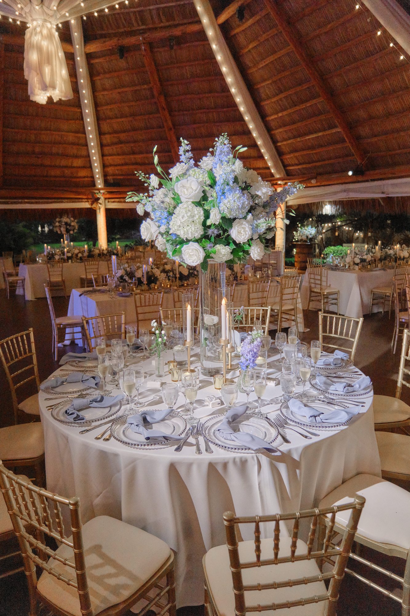 White and pale blue elevated centerpiece on a reception table