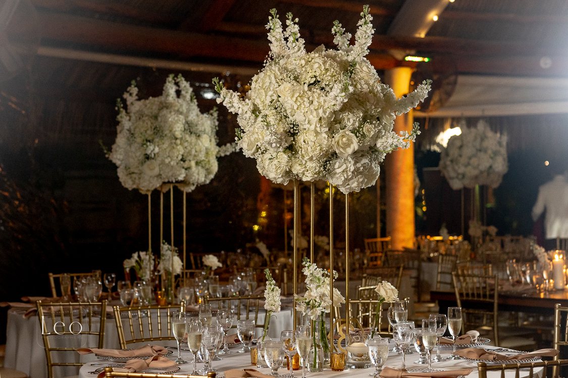 Tall white floral reception installations above dining tables